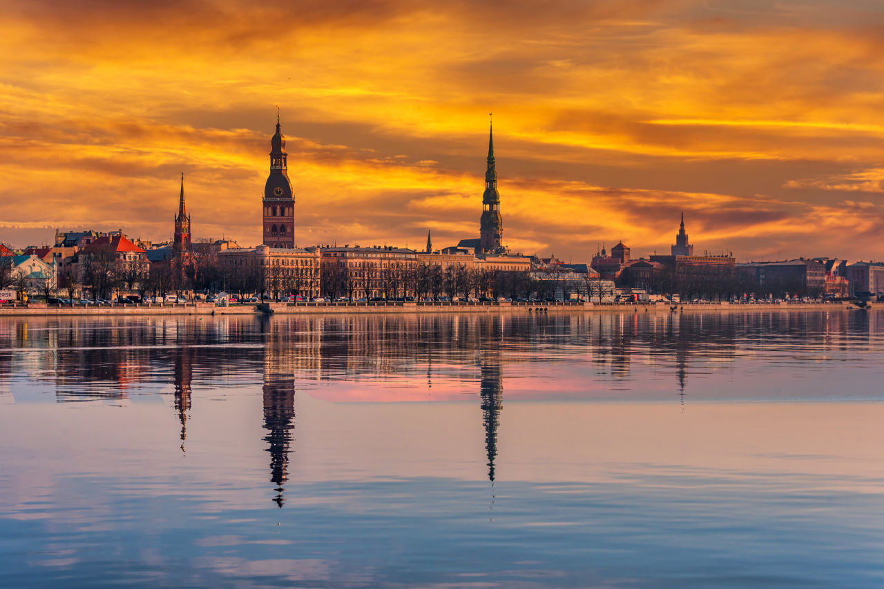 Sonnenuntergang über Riga mit Aussicht auf den Fluss und die dahinterliegende Stadt